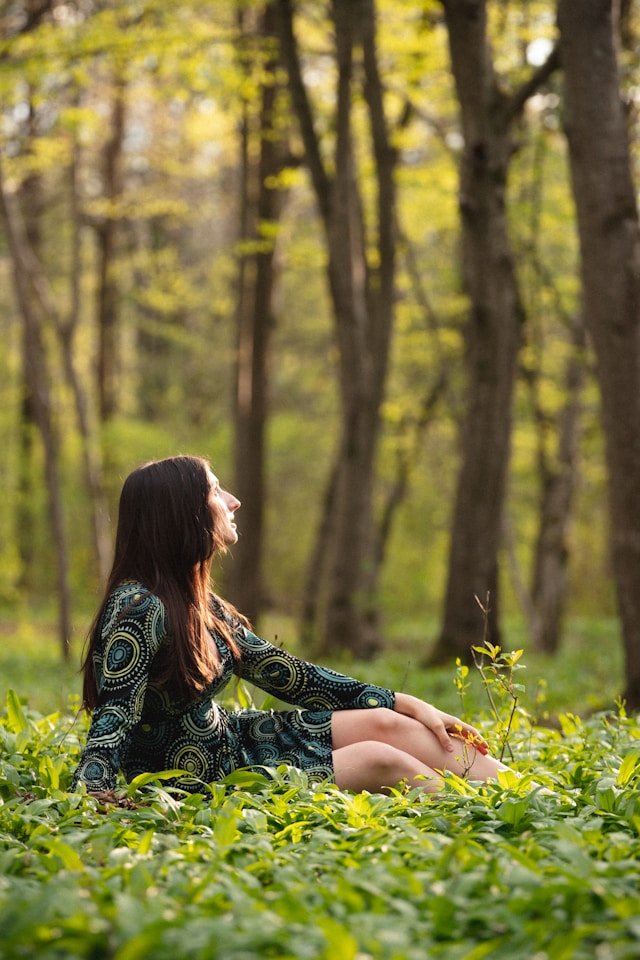 Mujer meditando al borde del acantilado rodeada de naturaleza