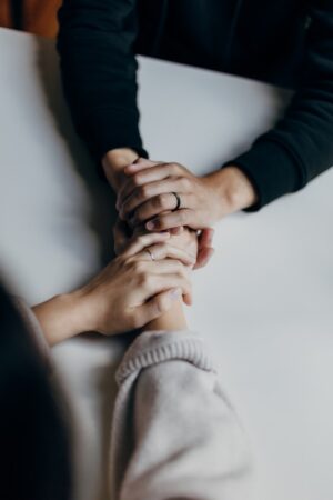 Manos unidas en gesto de conexión espiritual y sanación vibracional