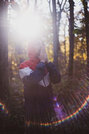 Persona meditando en un bosque sagrado rodeado de árboles milenarios