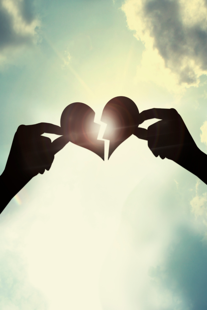 Manos sosteniendo un corazón roto en proceso de sanación emocional