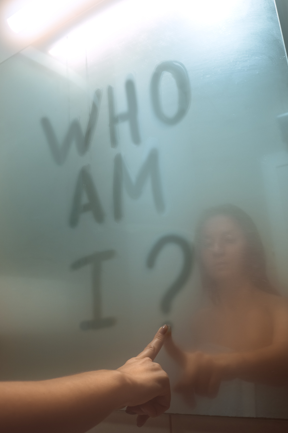 Reflejo de persona desenfocada en vidrio empañado buscando su verdadera esencia